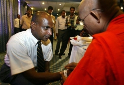 A monk putting blessed thread on an athlete.