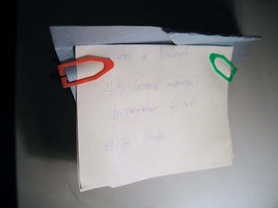 Attached to the paper airplane.