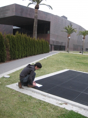 Ian attaches the note to the grate using colorful zip-ties