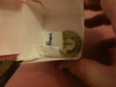 Adding the coin and fortune before sealing the top.