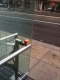 Balanced on a bus stop rail.